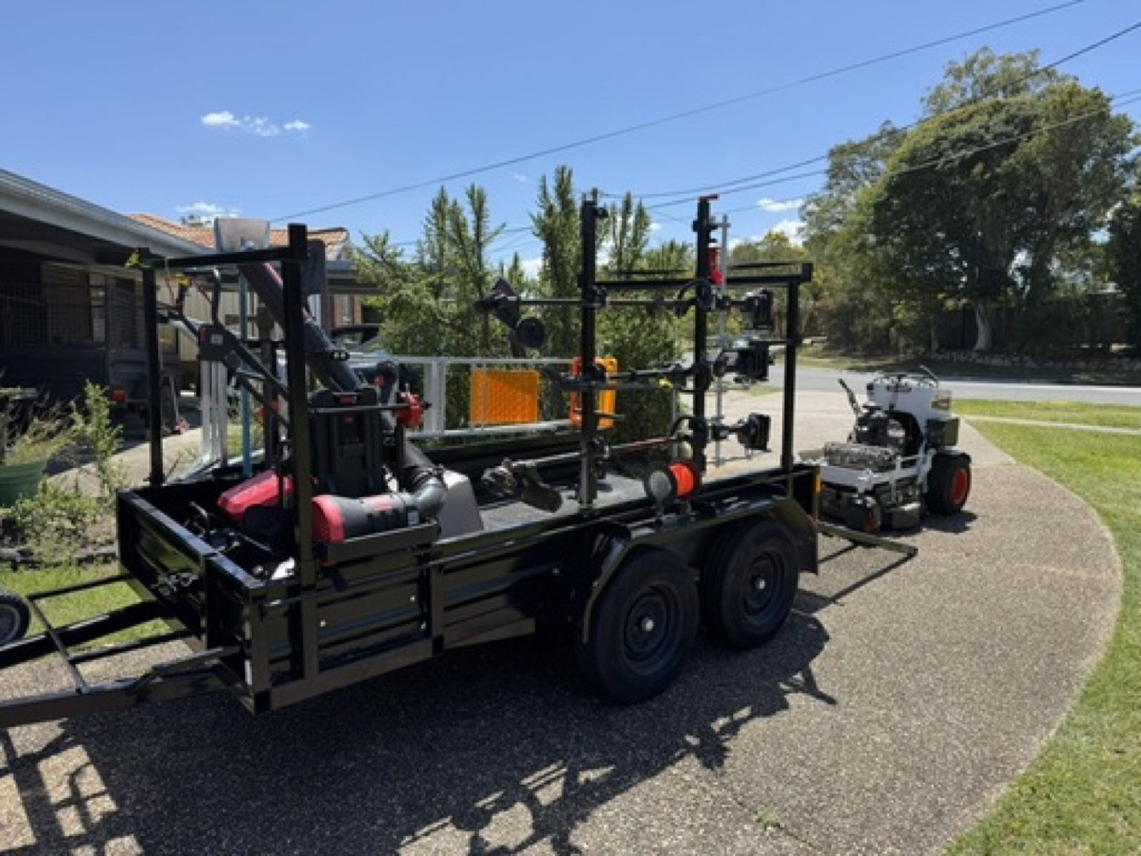 EcoMow professional equipment trailer with electric tools and Bobcat zero-turn mower